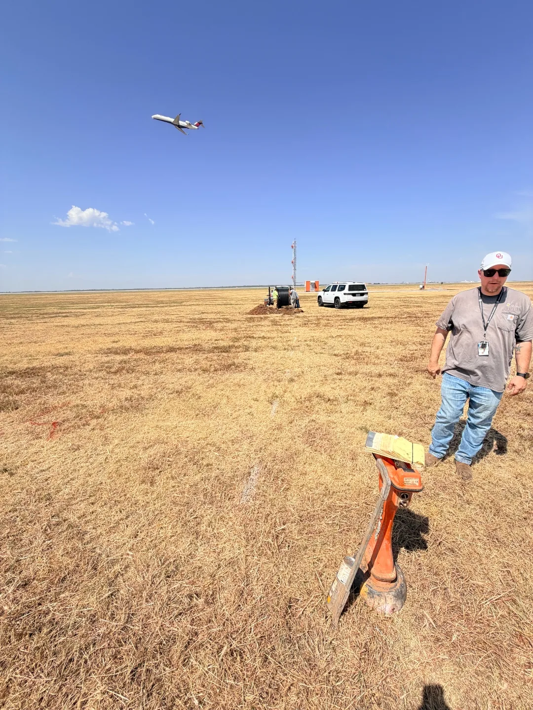 Commercial jet departing over the airfield while Trinity Boring Solutions installs conduit at Will Rogers World Airport in Oklahoma City
