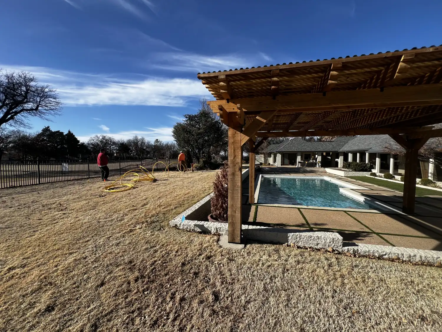 Residential Oklahoma backyard with pool and pergola where underground utility lines were installed